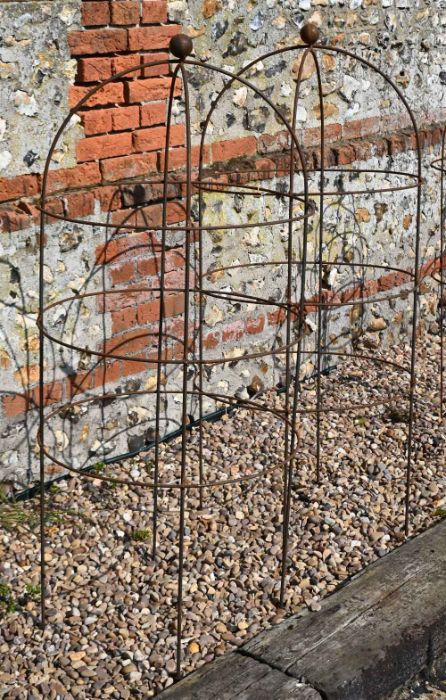 A pair of weathered steel ball head garden obelisks, 136 cm x 60 cm