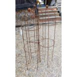 A trio of weathered steel ball-head garden obelisks