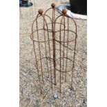 A trio of weathered steel ball-head garden obelisks