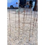 A pair of weathered steel ball-head garden obelisks