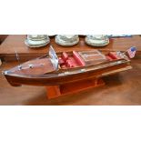 A static scale model of a Chris Craft Classic speed-boat on stand