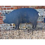 A black painted steel garden feature silhouette of a large standing pig
