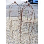 A trio of weathered steel ball-head garden obelisks