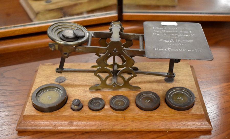 An antique set of brass postage scales on oak base, with weights