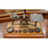 An antique set of brass postage scales on oak base, with weights