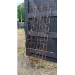 A pair of large weathered steel square section garden obelisk plant frames