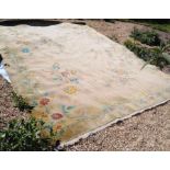 A large Chinese wool carpet with floral design on beige ground with camel border, 385 x 274 cm