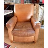 A contemporary distressed tan leather reclining library armchair
