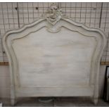 An old distressed painted French bed headboard
