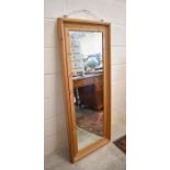 A rectangular wall mirror in moulded stained pine frame