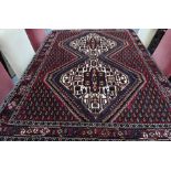 A Persian Bidjar twin lozenge boteh design on red-brown ground rug