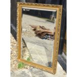 A bevelled wall mirror in decorative foliate gilt frame