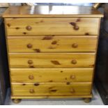A modern stained pine chest of five long drawers