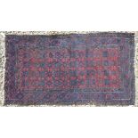 A Persian Baluchi red ground rug