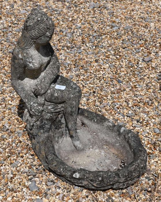 A reconstituted weathered stone bird bath