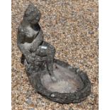 A reconstituted weathered stone bird bath