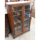 A glazed oak two-door display cabinet/bookcase