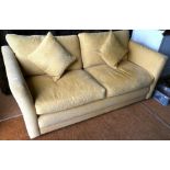 A contemporary three seater sofa in yellow upholstery