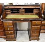 An early 20th century oak roll top desk