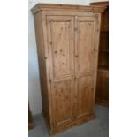 A small waxed pine wardrobe/hall cupboard