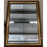 A modern bevelled wall mirror in decorative gilt frame