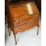An old crossbanded walnut bureau with fitted interior
