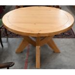 A modern light oak circular dining table