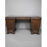 A Victorian carved and moulded oak twin pedestal sideboard
