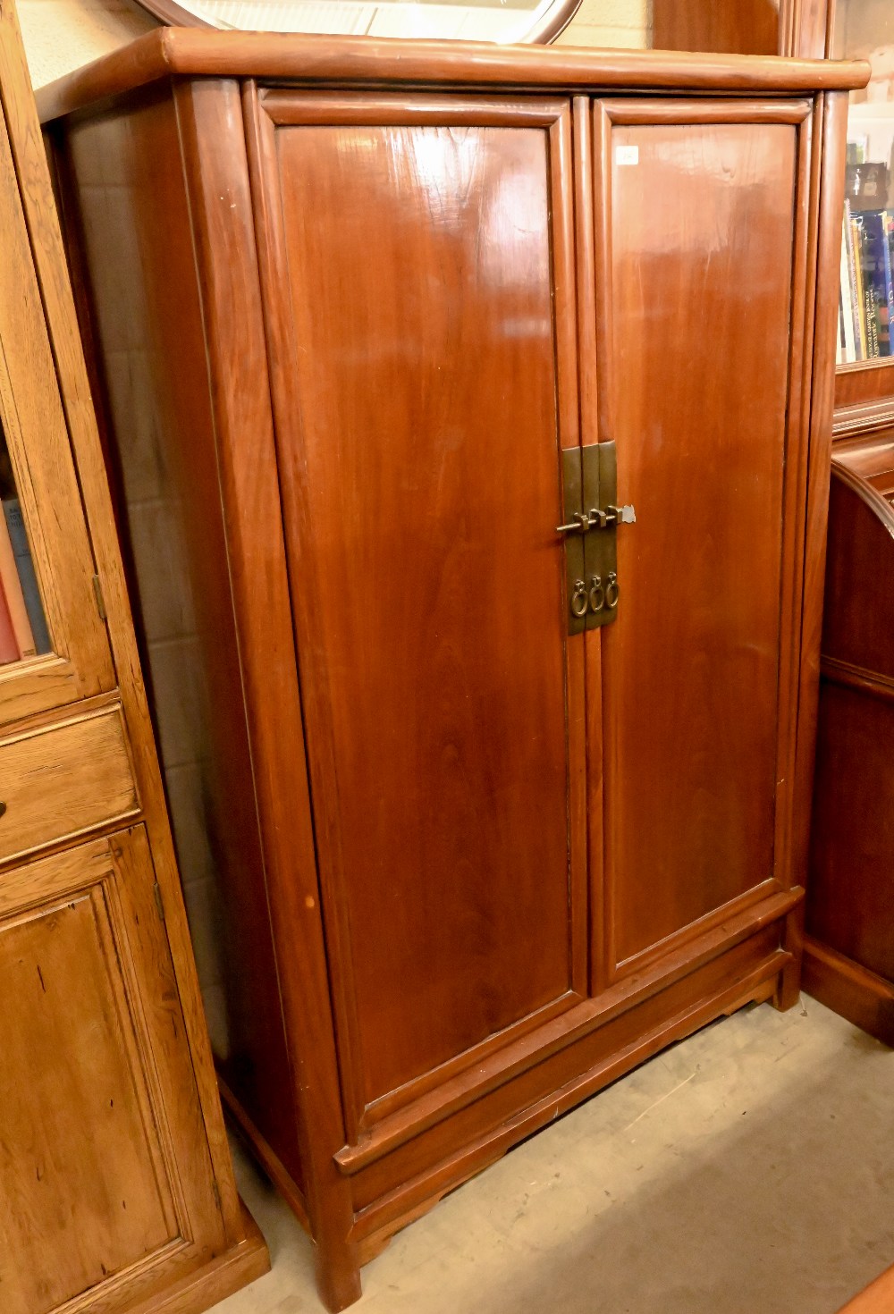 A Chinese hardwood and brass mounted two door cupboard, the interior fitted with shelves and two