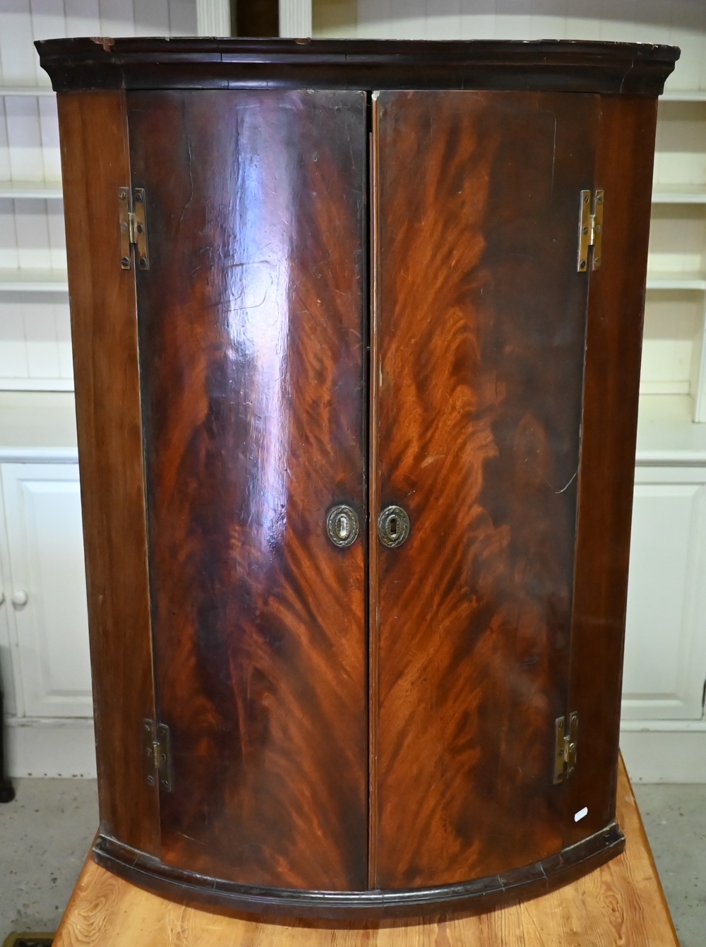 An 18th century flame mahogany barrel corner cupboard