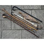 A bundle of sticks and umbrellas including shinty stick, Alpine stick with chamoix-horn handle etc