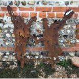 An aged steel garden feature silhouette of two boxing hares