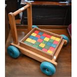 A vintage Galt Toys toddler's push-along wagon containing a set of painted wooden blocks