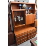 A McIntosh mid-century teak wall unit, the raised back with glazed door, drinks cabinet and open