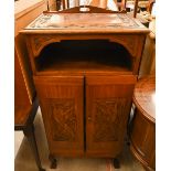 An Indonesian carved hardwood side cabinet with open shelf and two doors enclosing slides, on