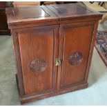 An Oriental rosewood drinks/cocktail cabinet with twin hinged panelled top over cupboard doors