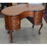 An early 20th century French mahogany kidney shaped desk with seven drawers raised on cabriole