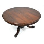 A Victorian rosewood breakfast table, the circular tilt top raised on a a moulded acanthus support