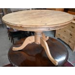 A waxed pine circular dining table on turned column and triform supports, 120 cm diam x 78 cm