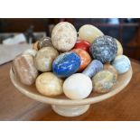 Collection of polished marble and other stone eggs, on turned alabaster tazza