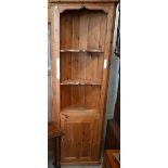 A stained pine floor standing corner unit with shelves over panelled cupboard doors, 200 cm high