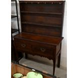 A small Georgian and later oak dresser with two shelf plate rack on base with two drawers and turned