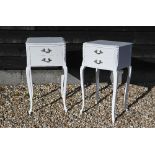A pair of white painted French bedside tables with floral carved decoration and slender cabriole