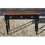 A narrow hall table with stained pine top on black painted three drawer base with turned and