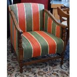 An early 20th century oak framed armchair with green and red striped fabric uphostery