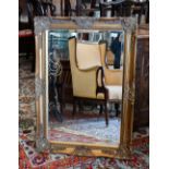 A bevelled rectangular wall mirror in decorative gilt frame with relief shell design, 90 x 65 cm