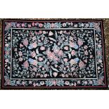 A traditional needlepoint rug, floral design on black ground, 183 x 123 cm
