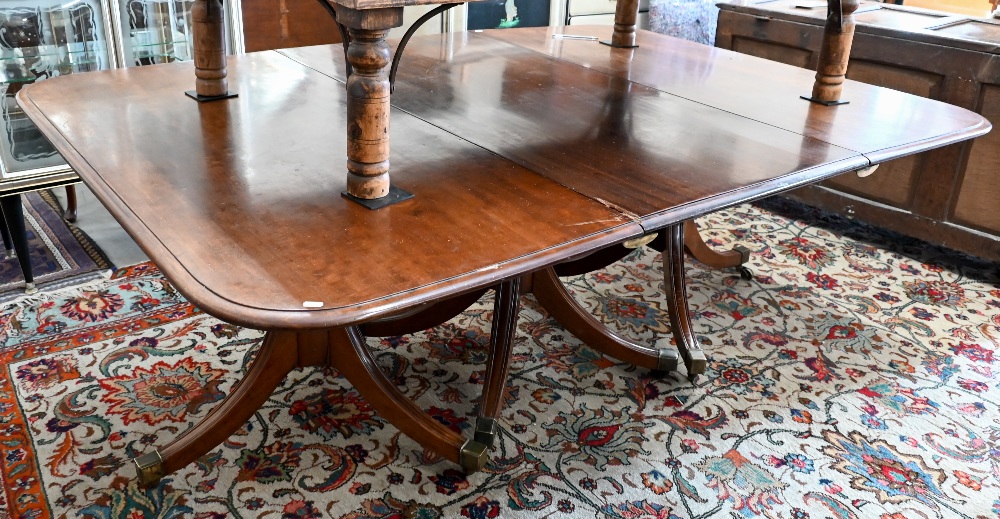 A 19th century mahogany extending dining table, the rounded rectangular top in three sections on
