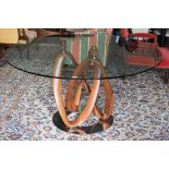 An Italian Porada Infinity dining table with circular glass top on an American walnut Mobius loop