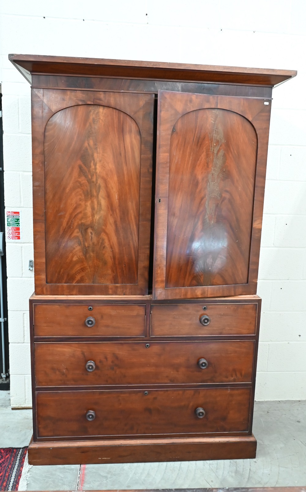 A 19th century mahogany wardrobe (converted from a linen press) with panelled doors enclosing